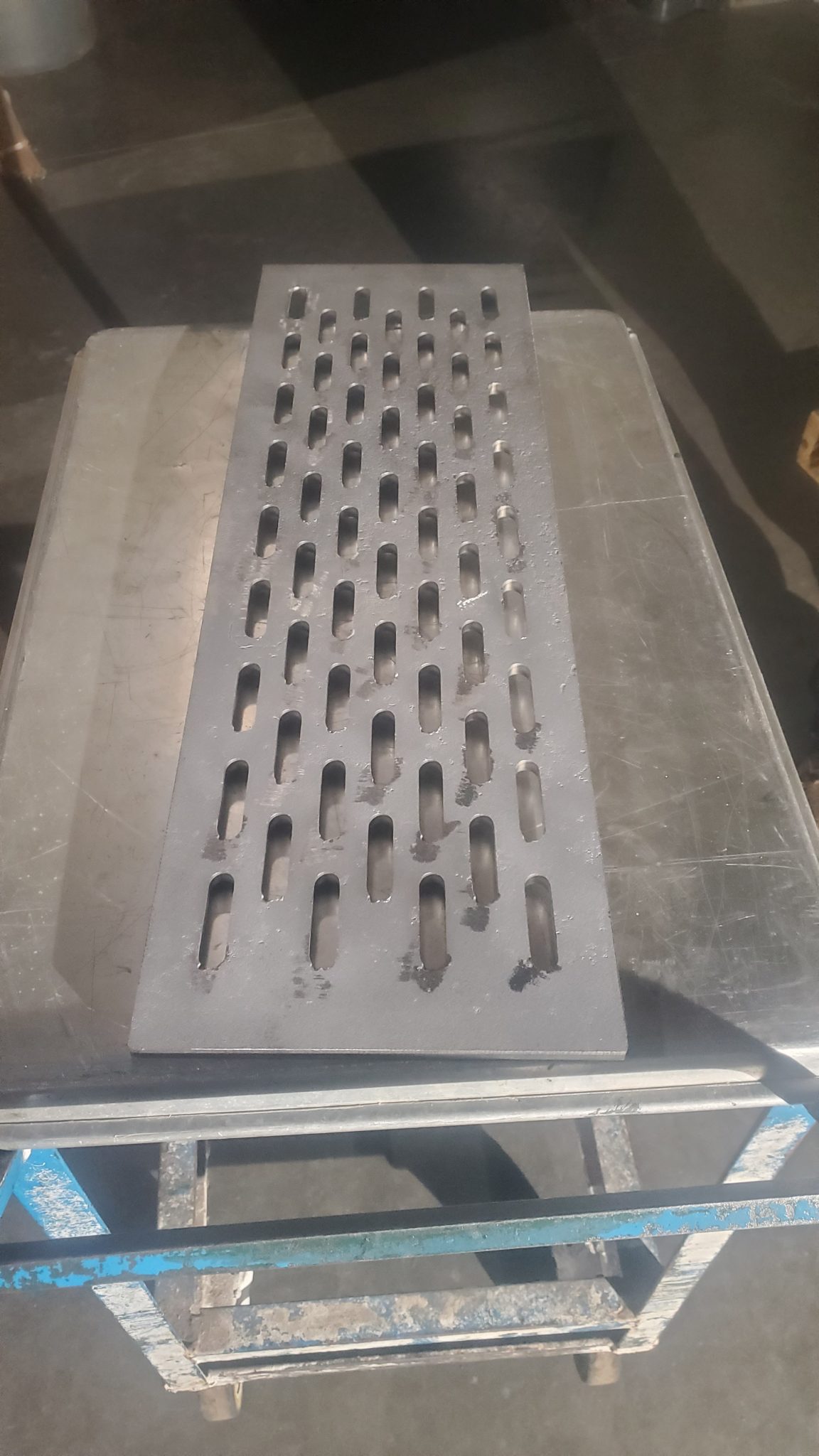 Custom steel grate panel post-cutting, part of CMDI’s metal fabrication project gallery.
