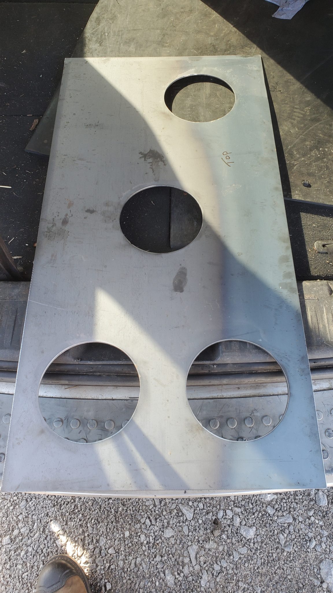 Steel plate with clean round cutouts, part of CMDI’s custom plasma cutting work.