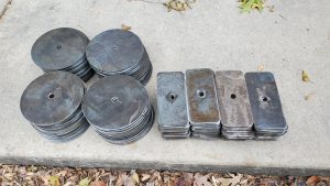 Small rectangular and circular parts from a detailed metal cutting and machining job.