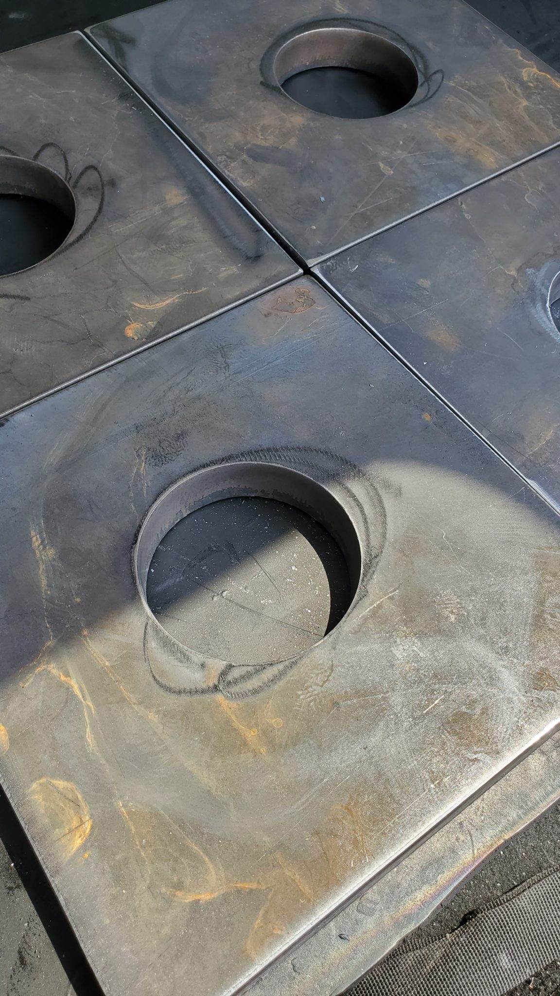 Precision-cut square and circular metal plates showcasing high-tolerance fabrication