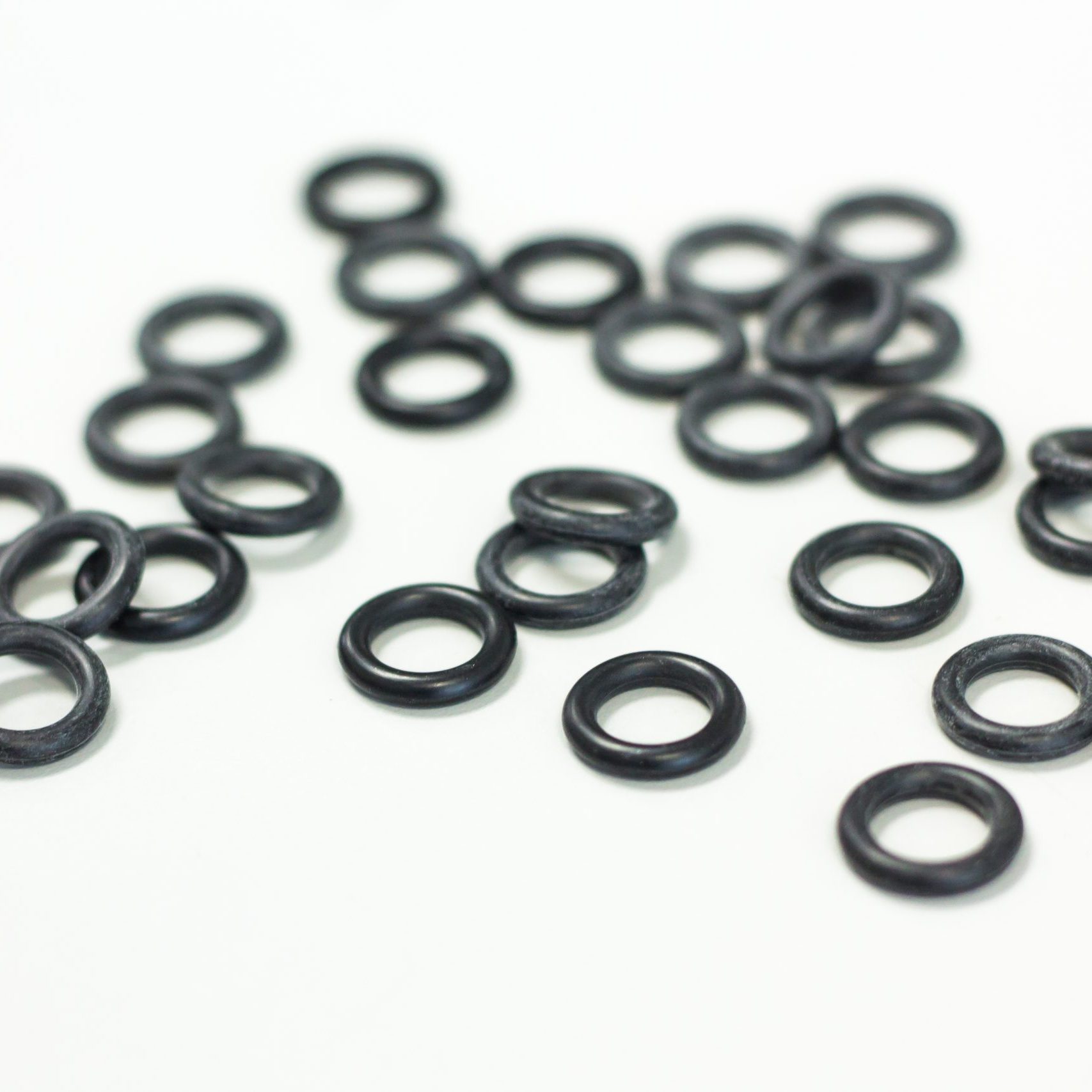 O-ring tool equipment, black O-Rings on white background.